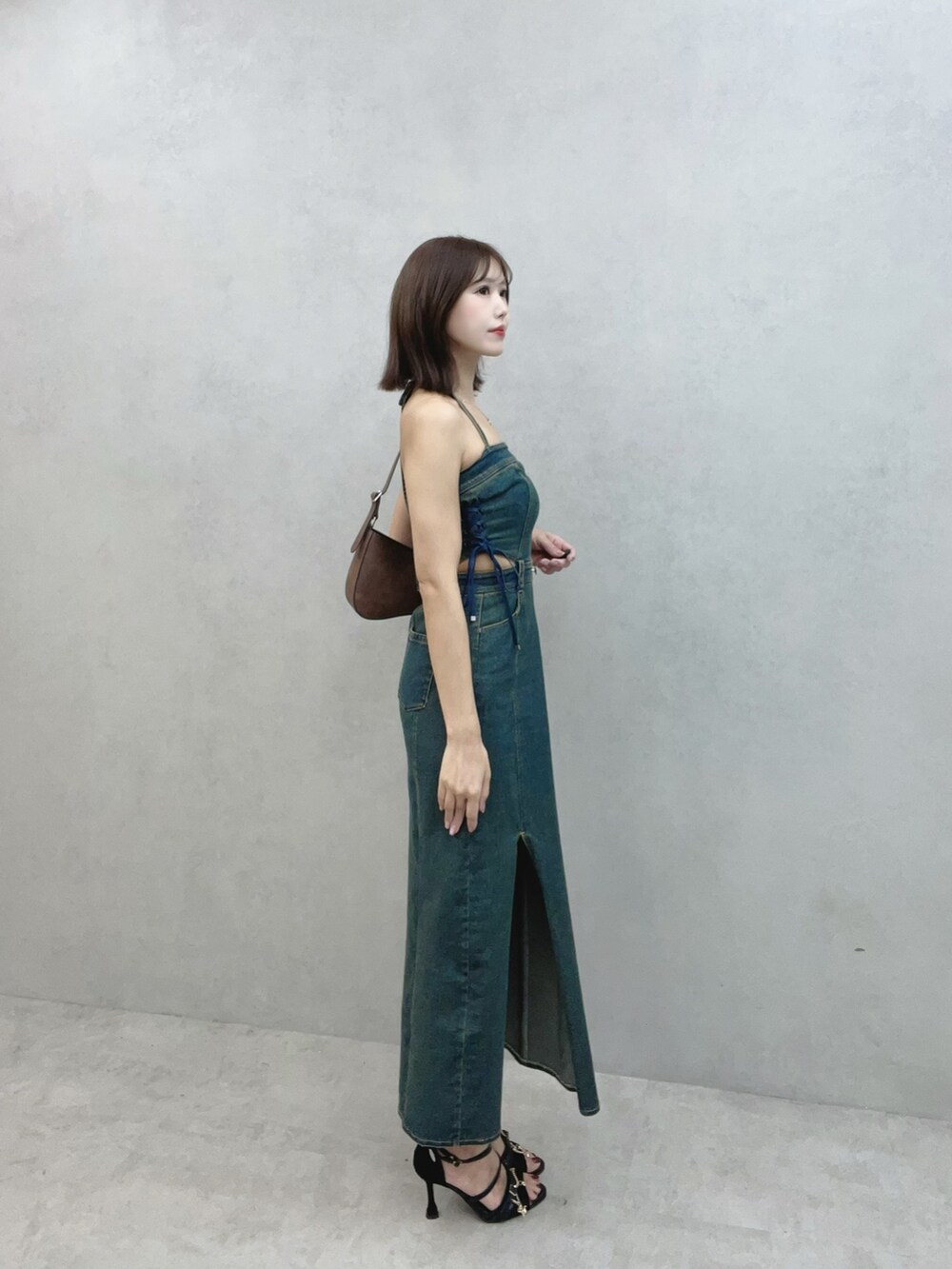 ブルー系のワンピース、ブラウン系のショルダーバッグ、ブラック系のサンダルを着用したレディースの秋コーディネートの2枚目の写真