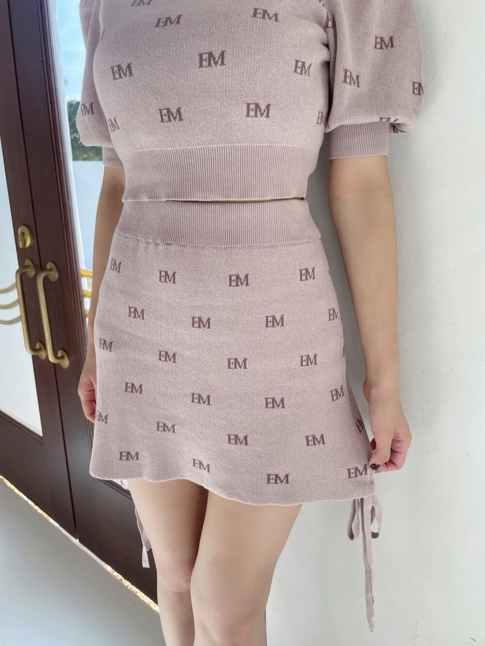 ピンク系のニット/セーター、ピンク系のスカート、ブラック系のパンプスを着用したレディースの冬コーディネートの8枚目の写真