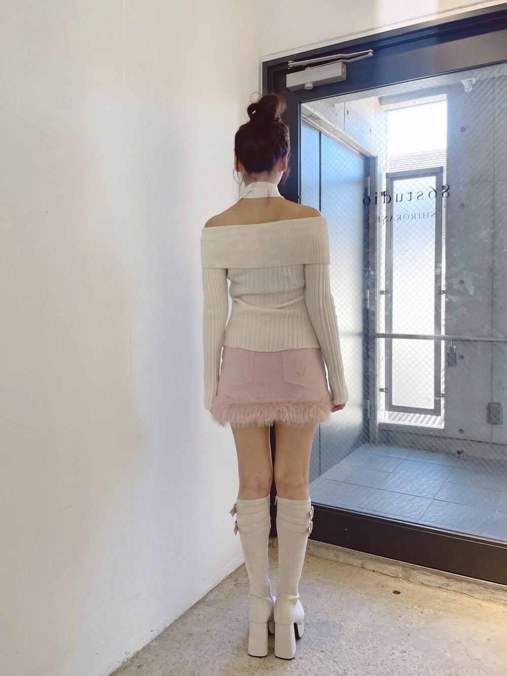 ホワイト系のニット/セーター、ホワイト系のブーツ、ピンク系のデニムスカートを着用したレディースの秋コーディネートの7枚目の写真