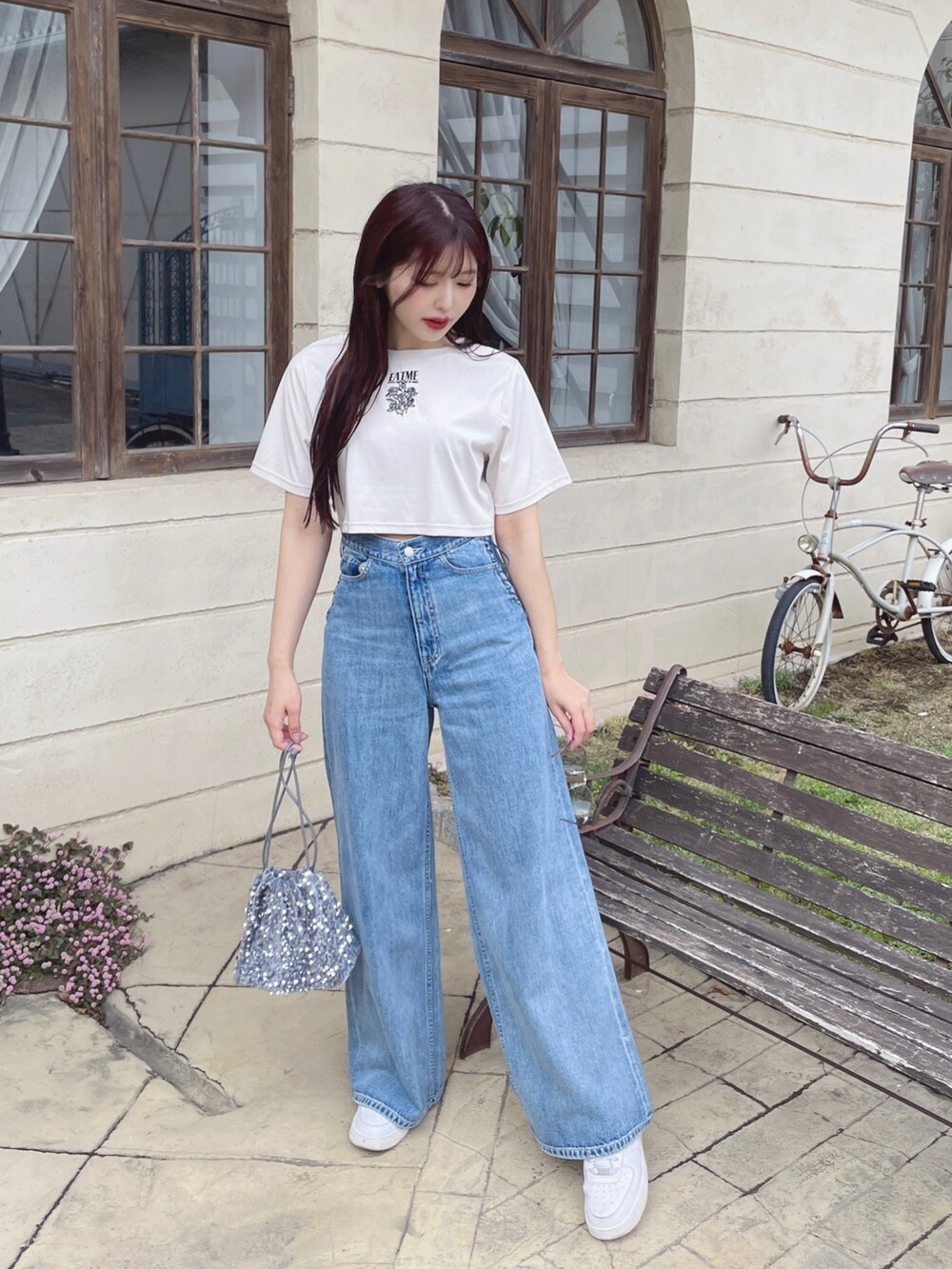 ブルー系のデニムパンツ、シルバー系のハンドバッグ、ホワイト系のTシャツ/カットソーを着用したレディースの春コーディネートの3枚目の写真