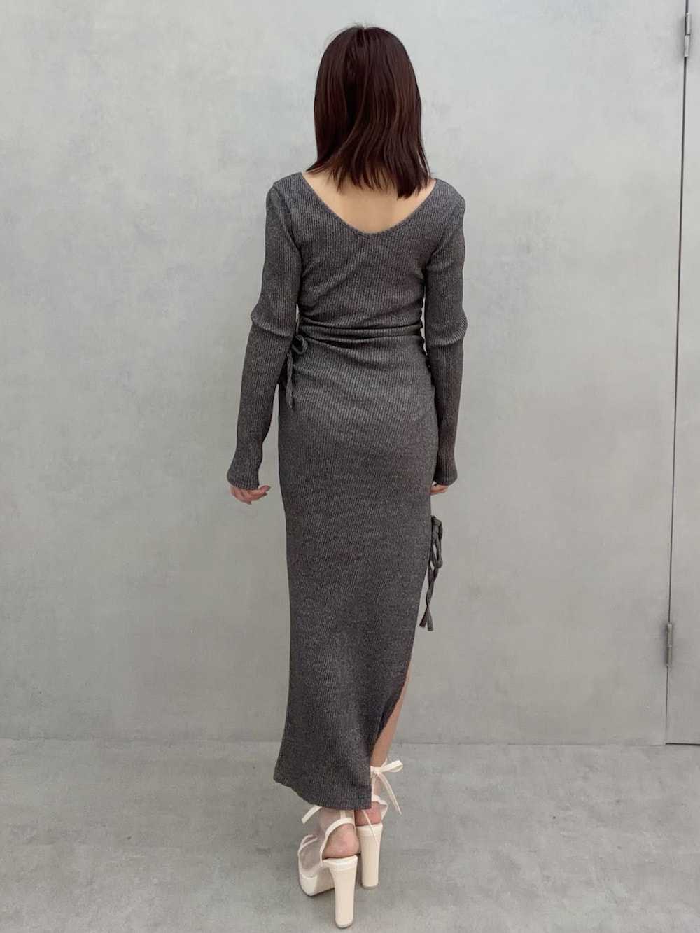 グレー系のワンピース、ホワイト系のサンダルを着用したレディースの冬コーディネートの5枚目の写真