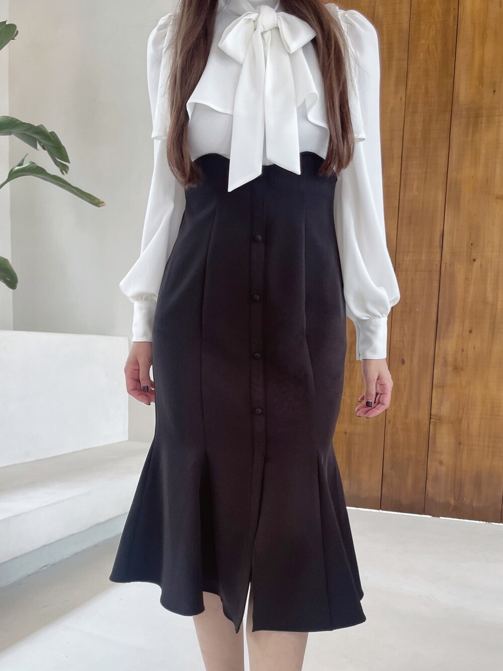 ブラック系のワンピース、ブラック系のショルダーバッグ、ブラック系のパンプスを着用したレディースの冬コーディネートの4枚目の写真