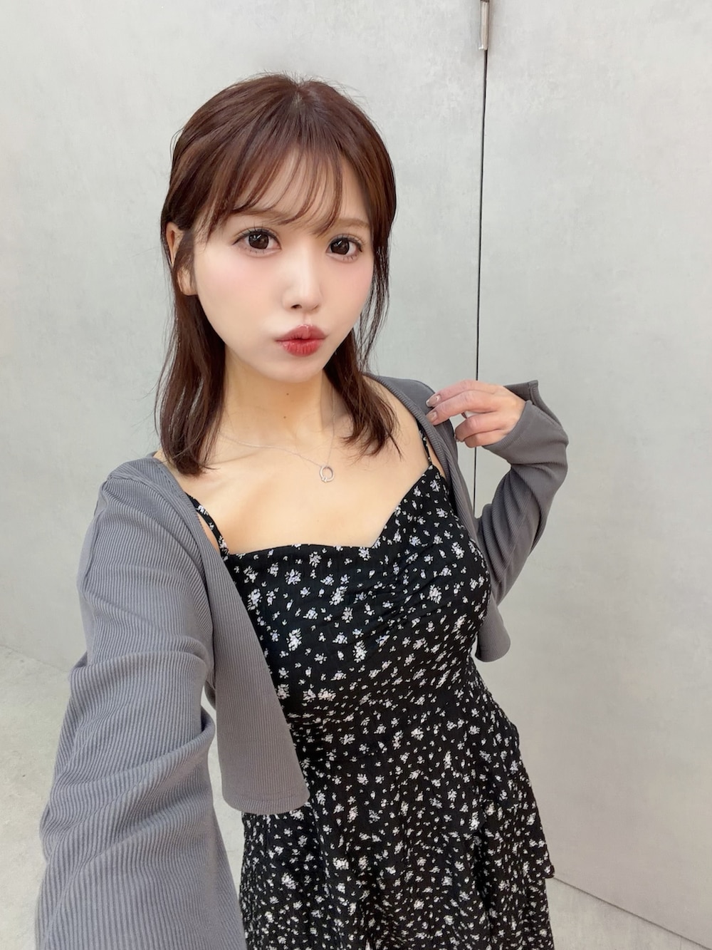 ブラック系のワンピース、ホワイト系のサンダル、グレー系のTシャツ/カットソーを着用したレディースの冬コーディネートの6枚目の写真