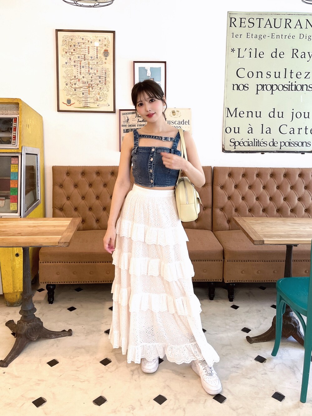 ホワイト系のスカート、イエロー系のボストンバッグ、ブルー系のキャミソールを着用したレディースの春コーディネートの2枚目の写真