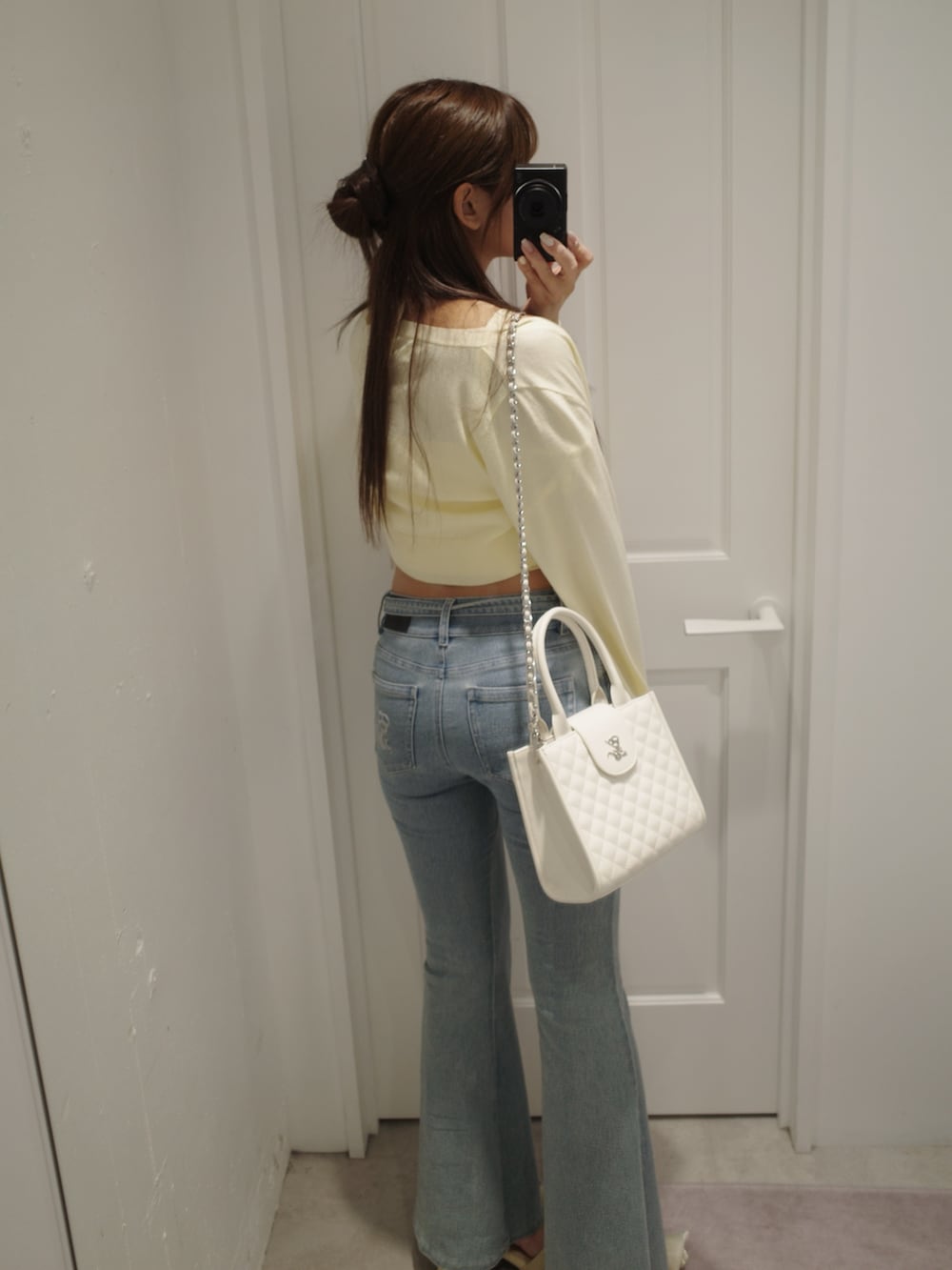 ブルー系のデニムパンツ、イエロー系のパンプス、イエロー系のニット/セーターを着用したレディースの夏コーディネートの6枚目の写真