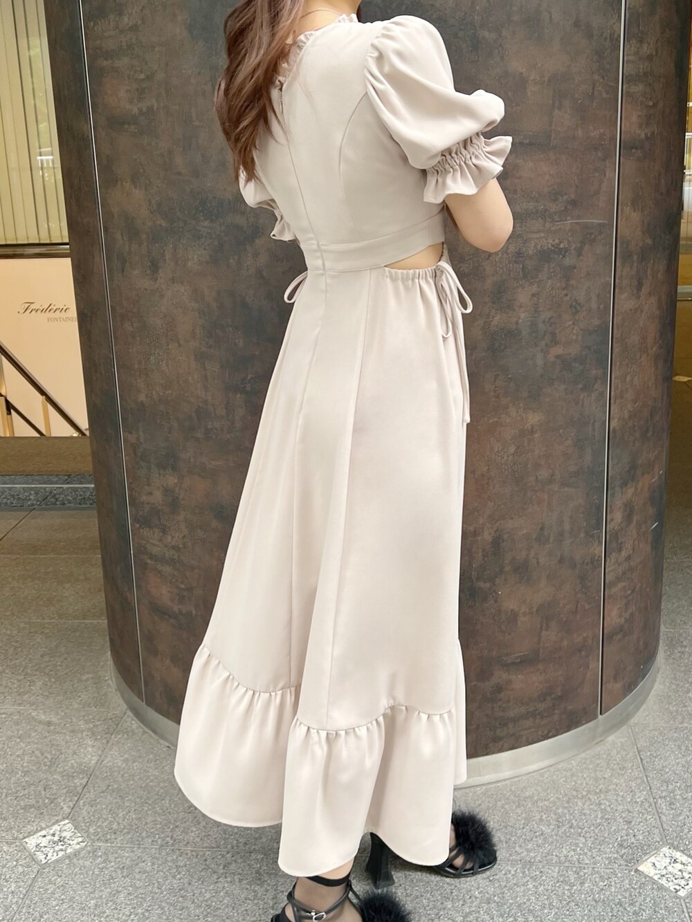 ブラック系のハンドバッグ、ベージュ系のワンピース、ブラック系のサンダルを着用したレディースの春コーディネートの5枚目の写真