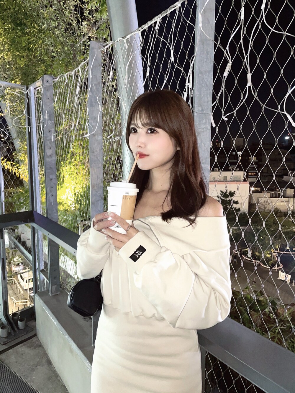 ブラック系のショルダーバッグ、ホワイト系のワンピースを着用したレディースの秋コーディネートの7枚目の写真