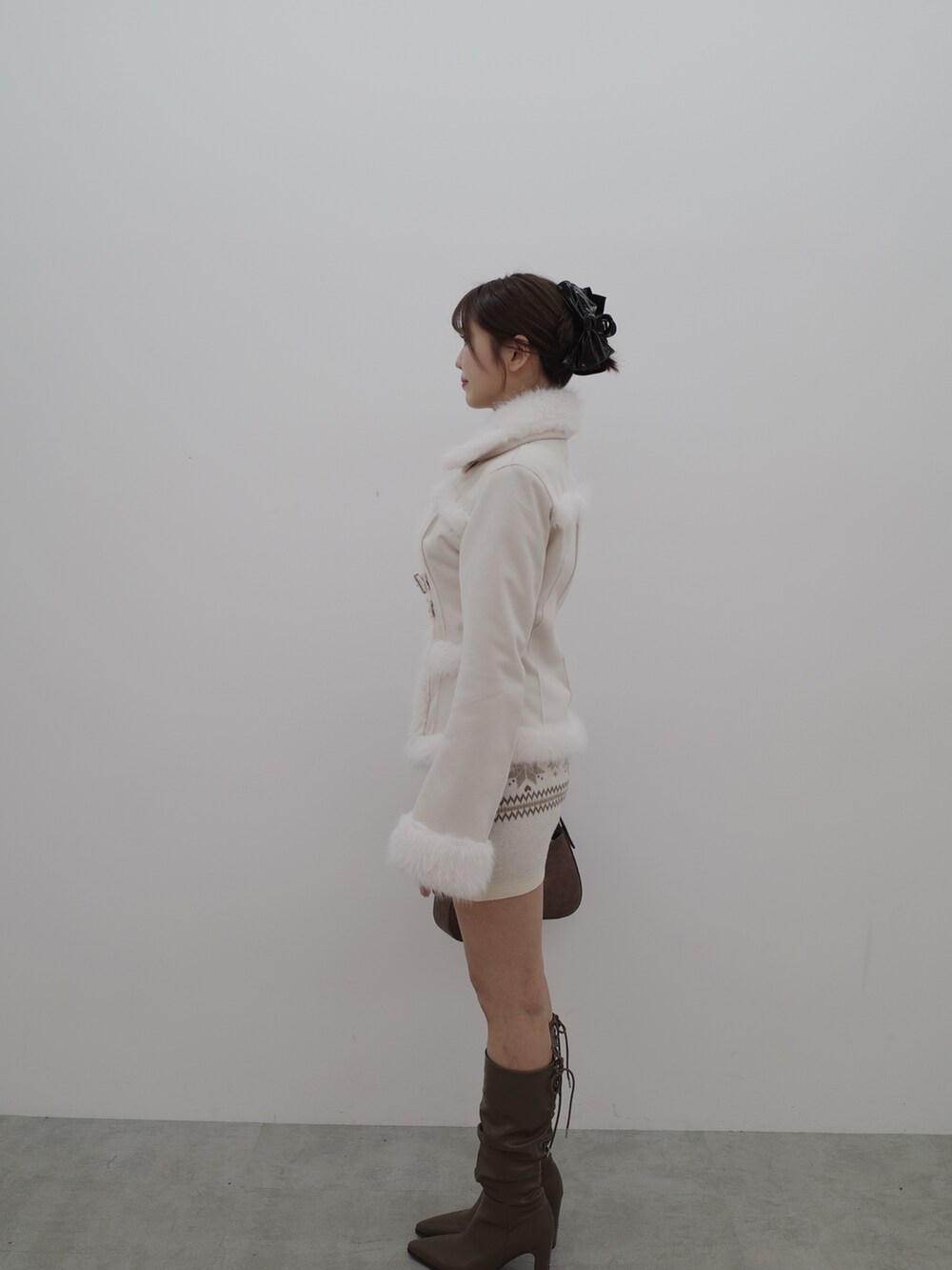 ホワイト系のブルゾン、ホワイト系のスカート、ブラウン系のショルダーバッグを着用したレディースの秋コーディネートの5枚目の写真