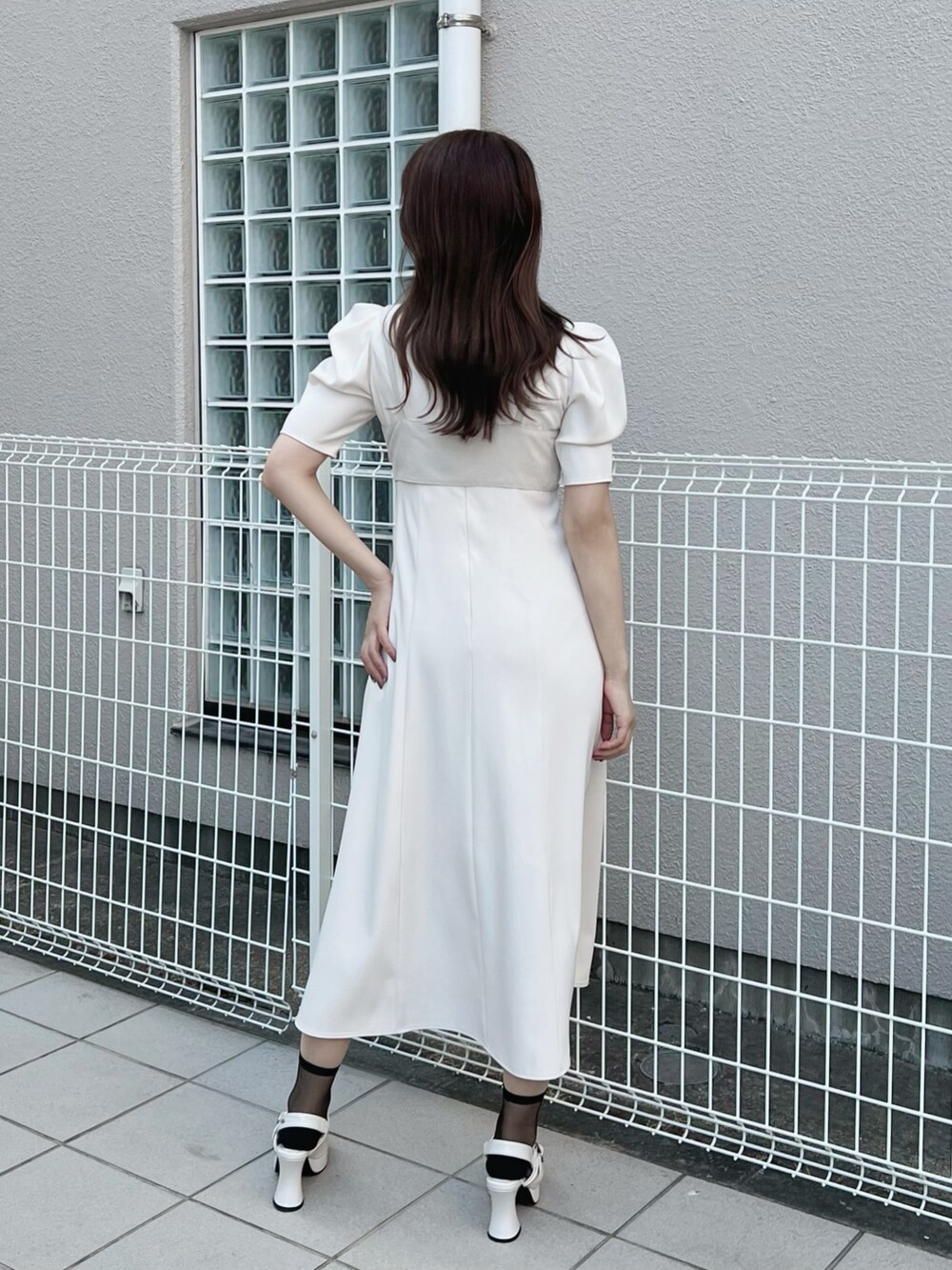 ホワイト系のワンピース、ホワイト系のパンプス、その他のピアス（両耳用）を着用したレディースの夏コーディネートの7枚目の写真