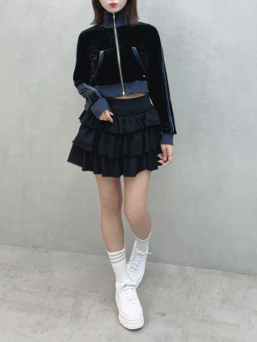 ブラック系のブルゾン、ブラック系のスカート、ホワイト系のスニーカーを着用したレディースの秋コーディネートの2枚目の写真
