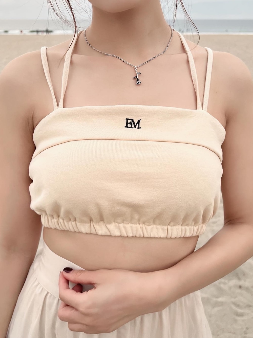 イエロー系のキャミソール、ベージュ系のスカートを着用したレディースの春コーディネートの6枚目の写真