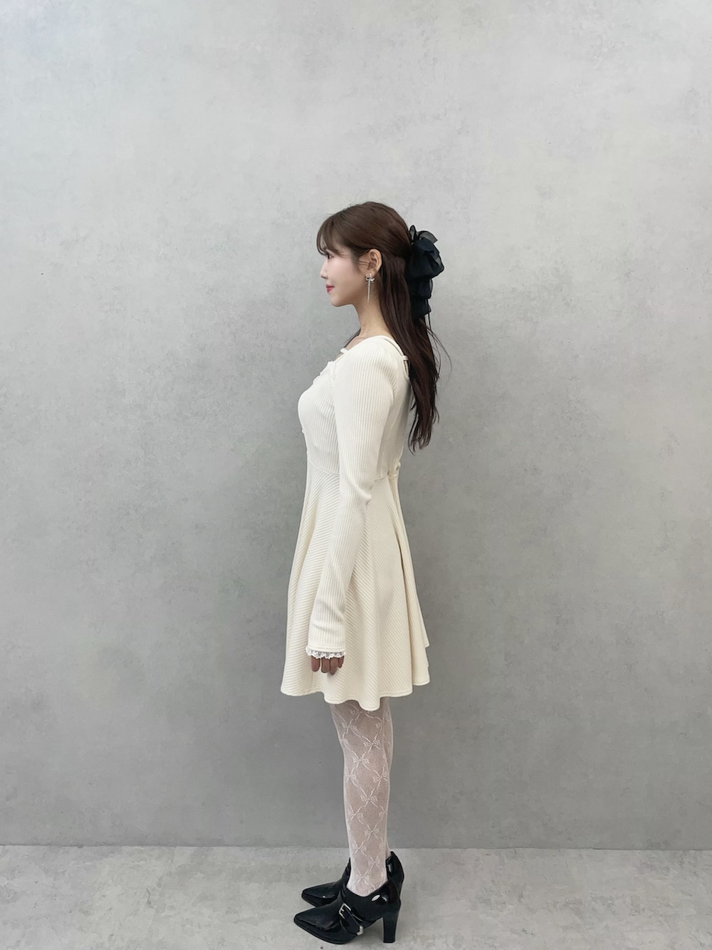 ホワイト系のワンピース、ブラック系のブーツを着用したレディースの冬コーディネートの6枚目の写真