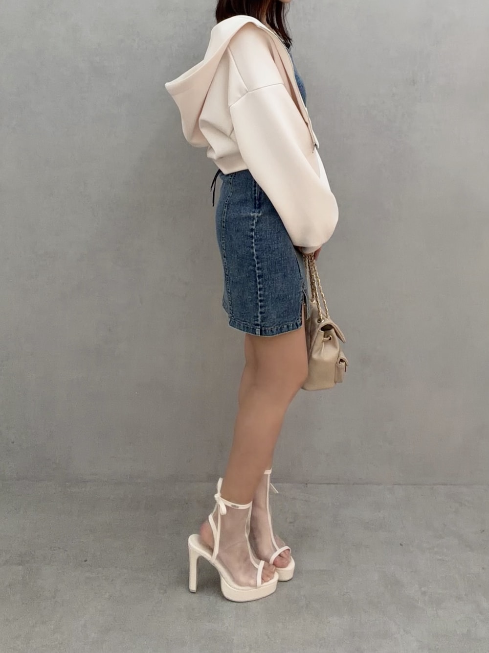 ブルー系のワンピース、ホワイト系のパーカー、ベージュ系のバックパック/リュックを着用したレディースの冬コーディネートの3枚目の写真