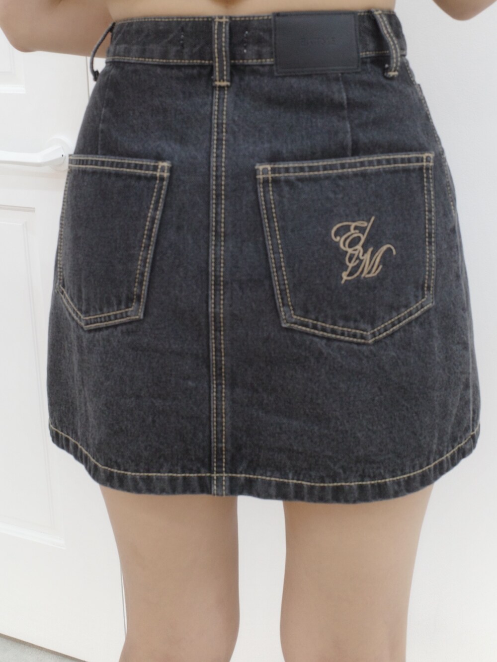 ブラック系のデニムスカート、ホワイト系のTシャツ/カットソーを着用したレディースの夏コーディネートの7枚目の写真