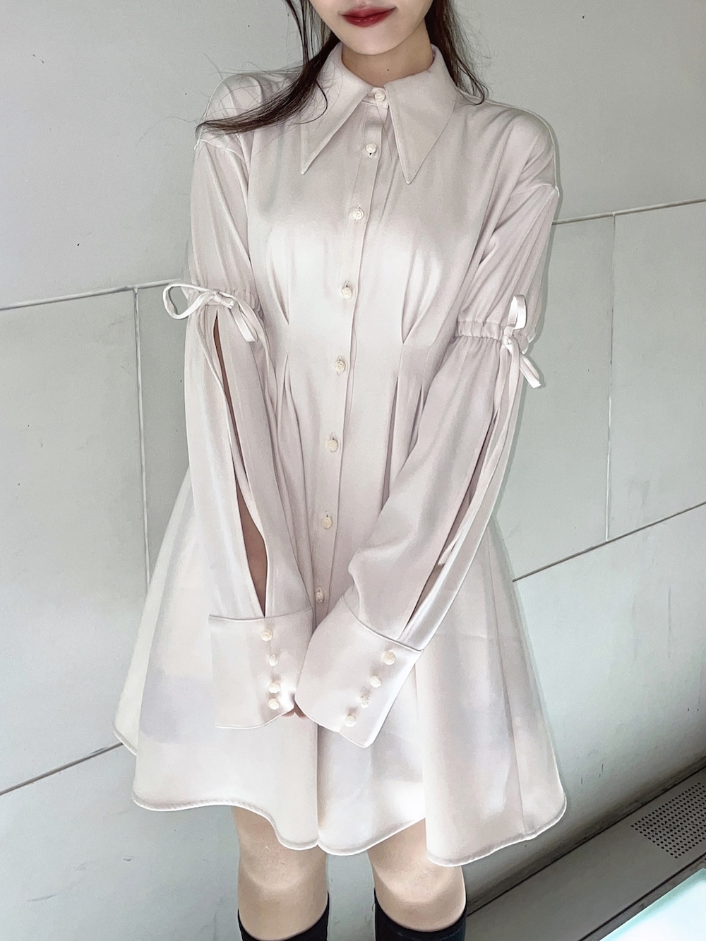 ホワイト系のワンピース、ブラック系のブーツを着用したレディースの冬コーディネートの2枚目の写真