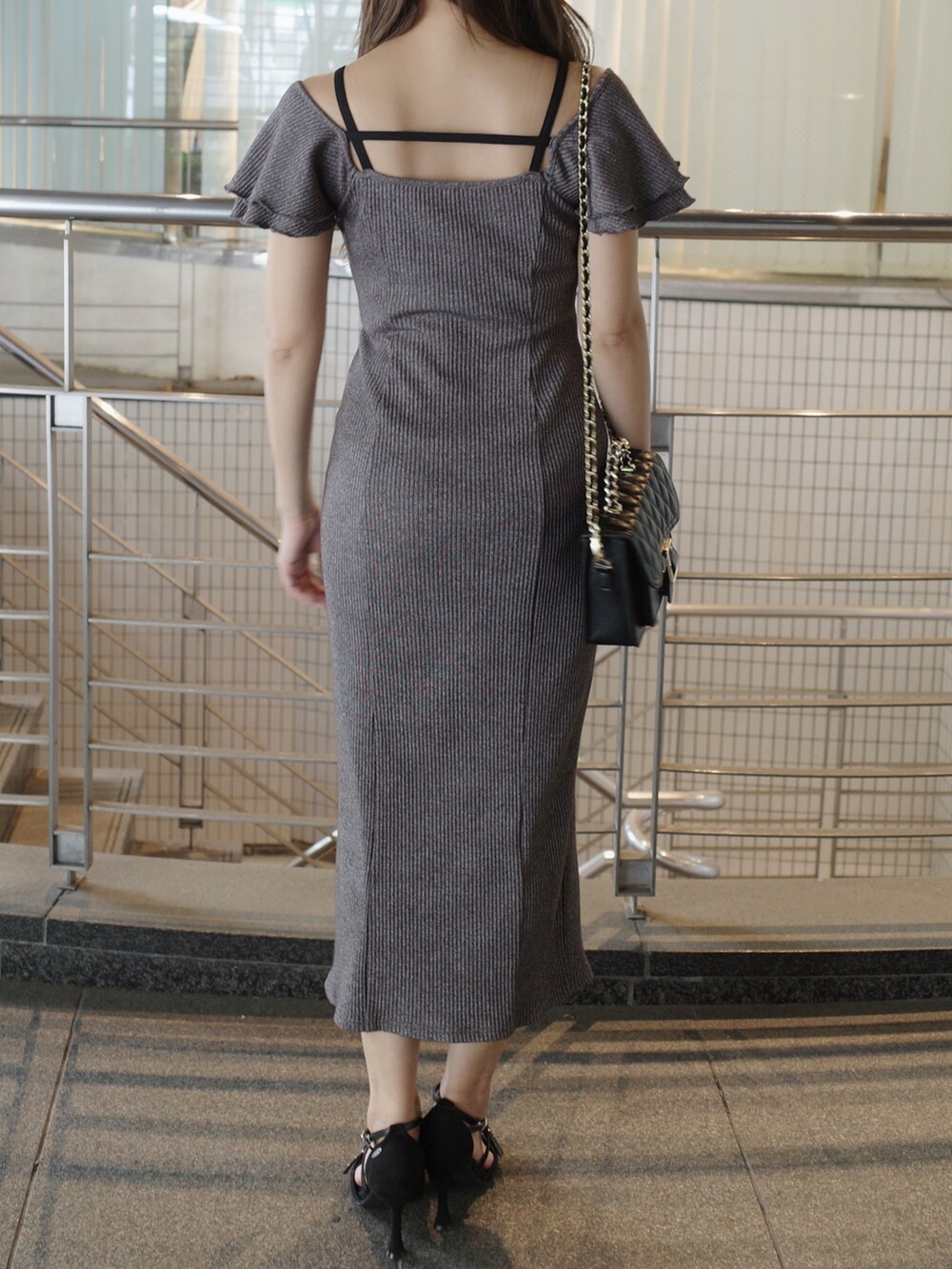 グレー系のワンピース、ブラック系のサンダル、ブラック系のショルダーバッグを着用したレディースの夏コーディネートの6枚目の写真