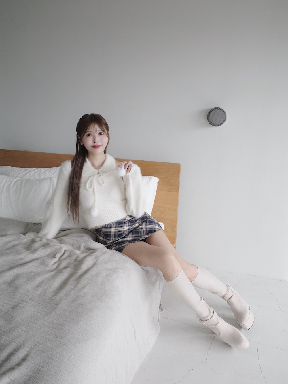 ホワイト系のニット/セーター、ブルー系のスカート、ホワイト系のブーツを着用したレディースの秋コーディネートの5枚目の写真