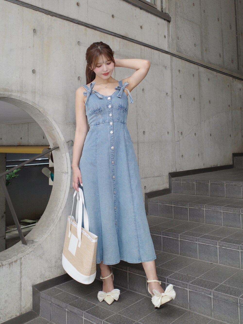 ホワイト系のトートバッグ、イエロー系のパンプス、ブルー系のワンピースを着用したレディースの夏コーディネートの2枚目の写真