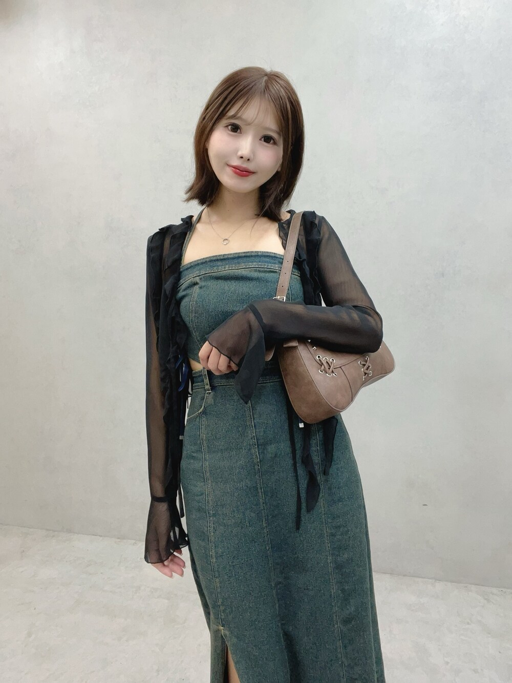 ブラック系のサンダル、ブルー系のワンピース、ブラウン系のショルダーバッグを着用したレディースの秋コーディネートの4枚目の写真