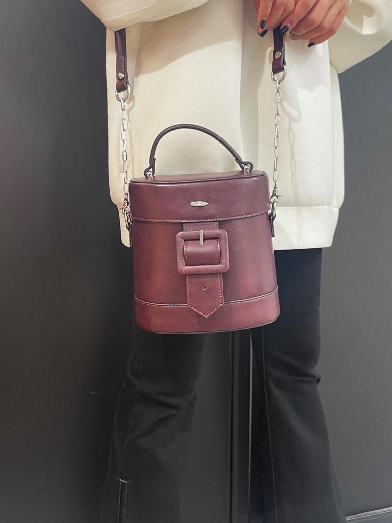 レッド系のショルダーバッグ、ブラック系のその他シューズ、ブラック系のデニムパンツを着用したレディースの秋コーディネートの4枚目の写真