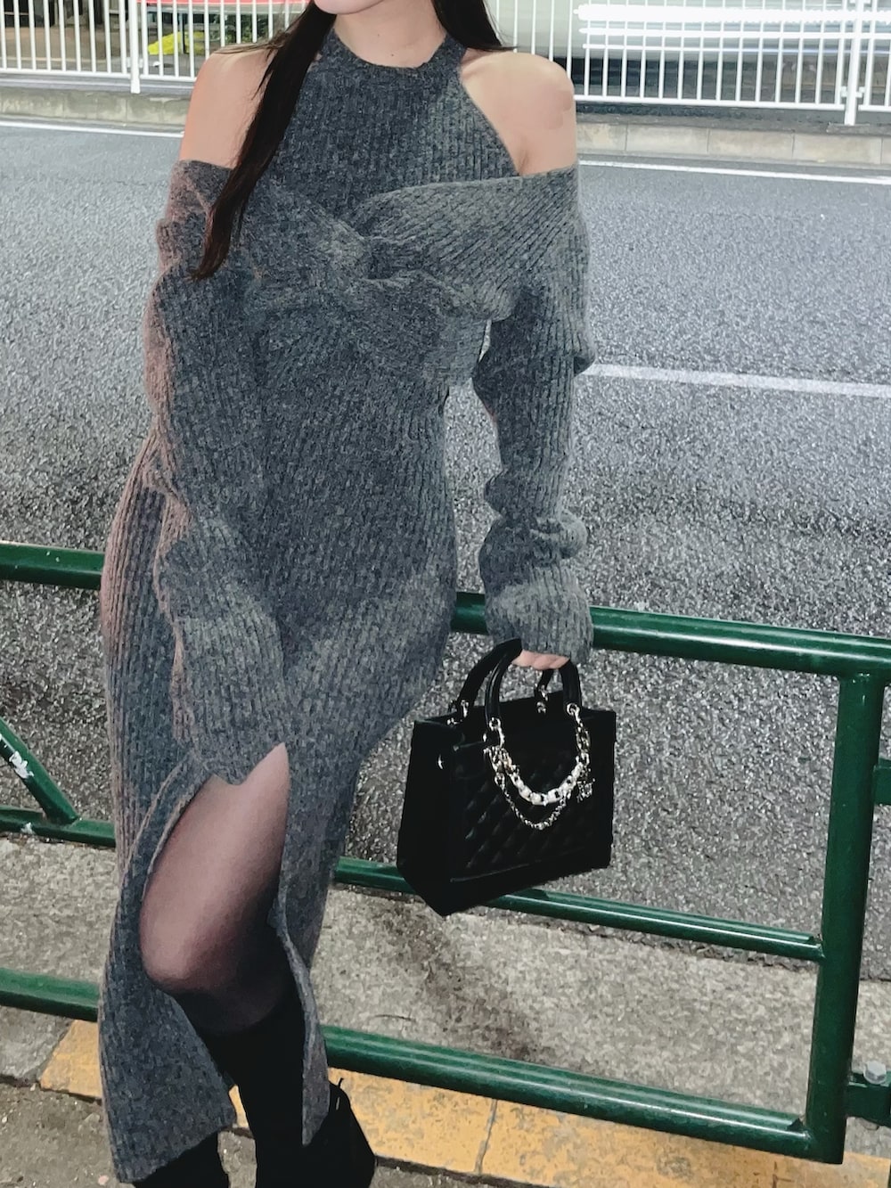 グレー系のワンピース、ブラック系のハンドバッグ、ブラック系のブーツを着用したレディースの冬コーディネートの8枚目の写真