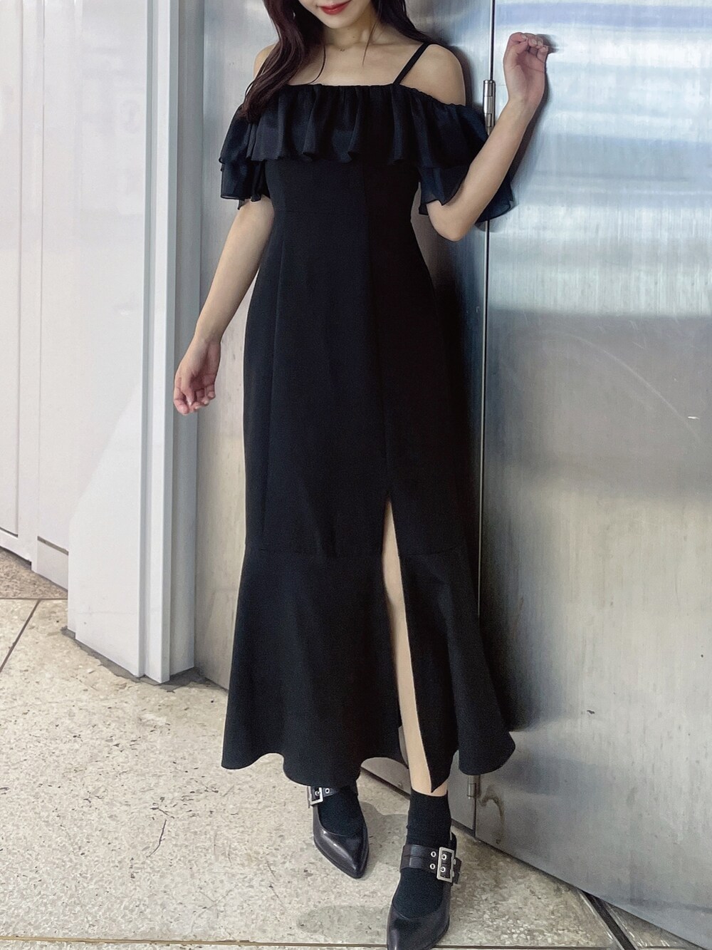 ブラック系のワンピース、ブラック系のパンプスを着用したレディースの春コーディネートの2枚目の写真