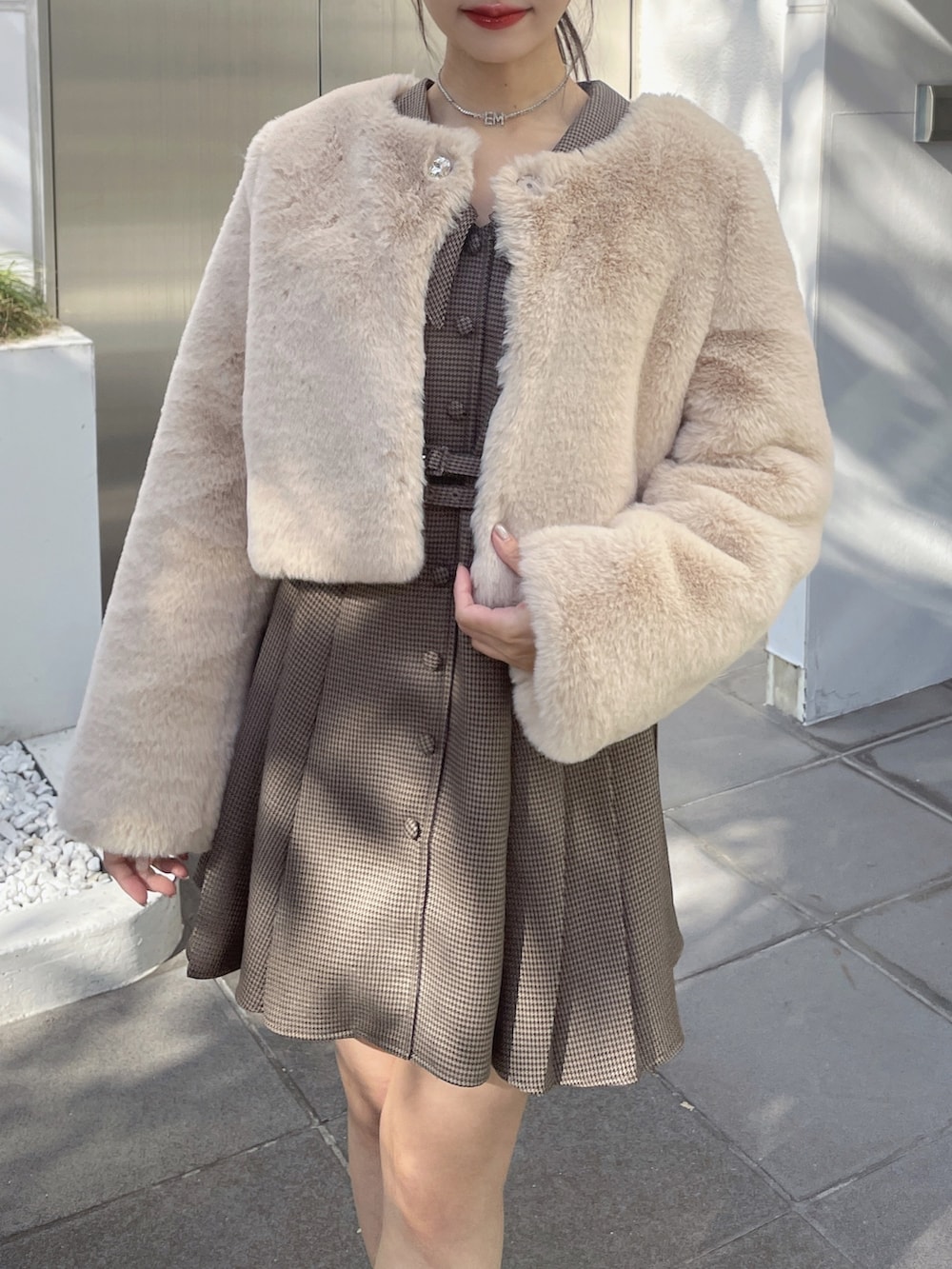 ブラウン系のワンピース、ベージュ系のその他アウター、ブラック系のローファーを着用したレディースの冬コーディネートの5枚目の写真