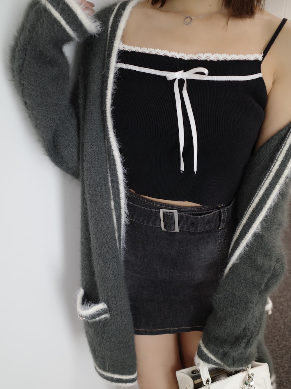 ブラック系のニット/セーター、グレー系のワンピース、ブルー系のデニムスカートを着用したレディースの秋コーディネートの8枚目の写真