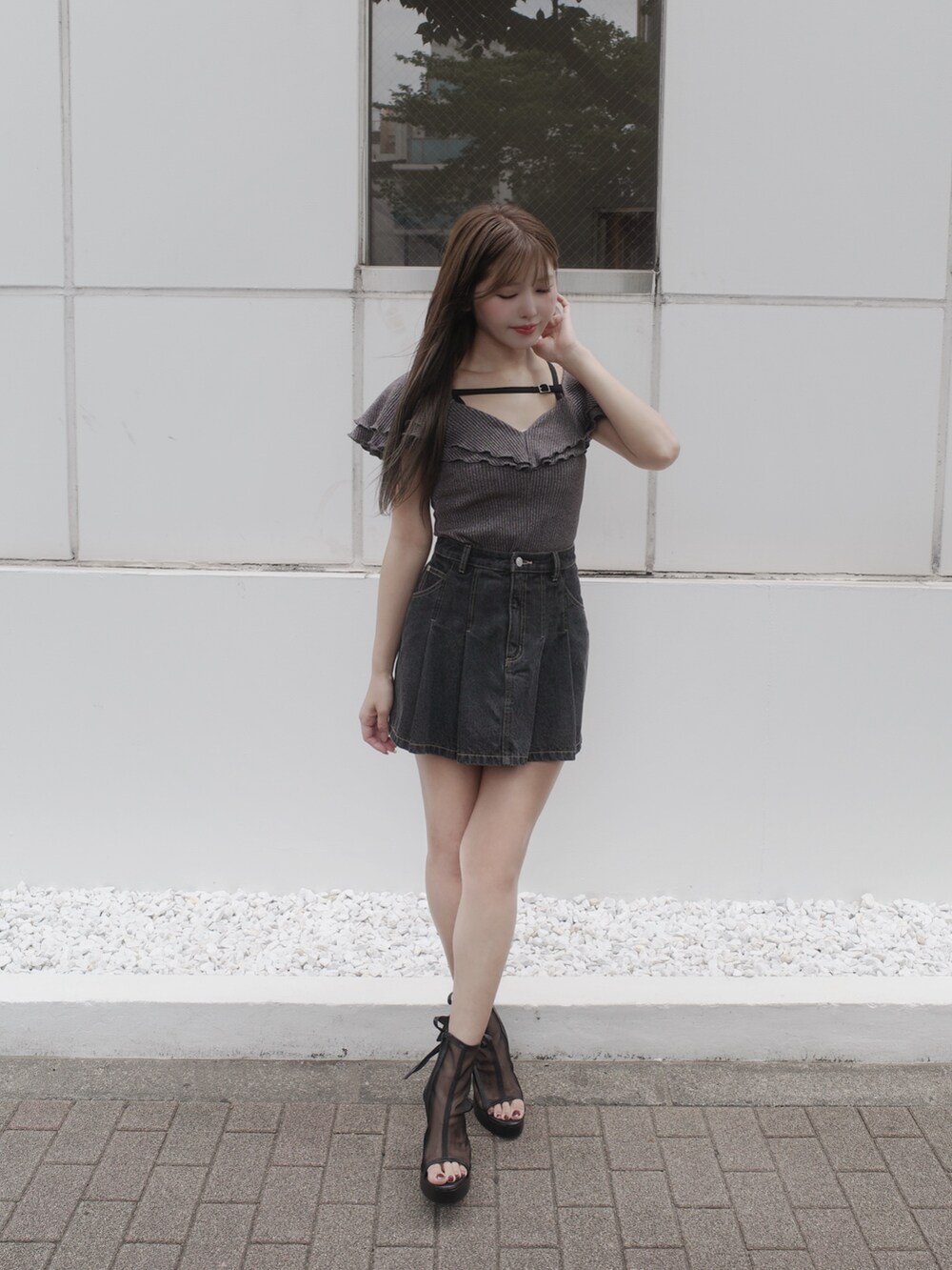 ブラック系のデニムスカート、ブラック系のサンダル、グレー系のTシャツ/カットソーを着用したレディースの夏コーディネートの3枚目の写真