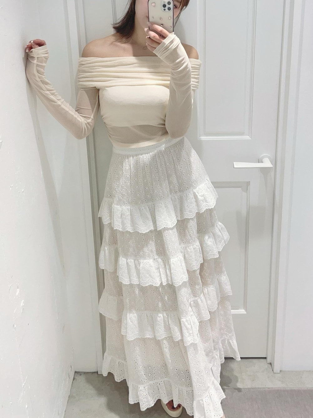 ホワイト系のスカート、ホワイト系のTシャツ/カットソー、ホワイト系のサンダルを着用したレディースの春コーディネートの2枚目の写真