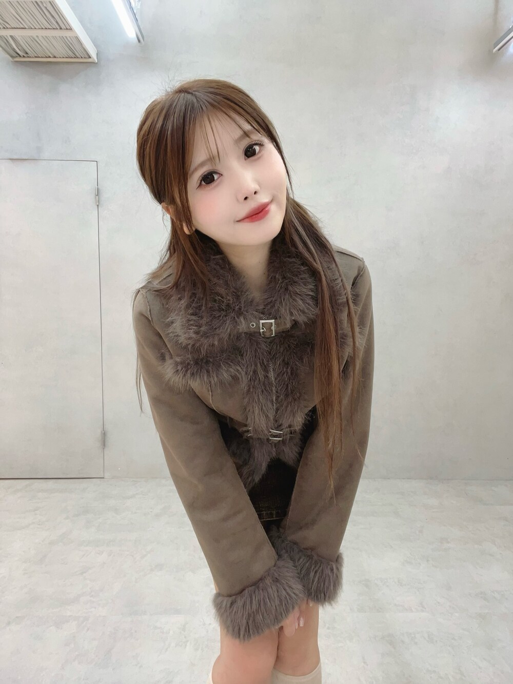 ホワイト系のブーツ、ブラウン系のブルゾン、ブラウン系のデニムスカートを着用したレディースの夏コーディネートの4枚目の写真