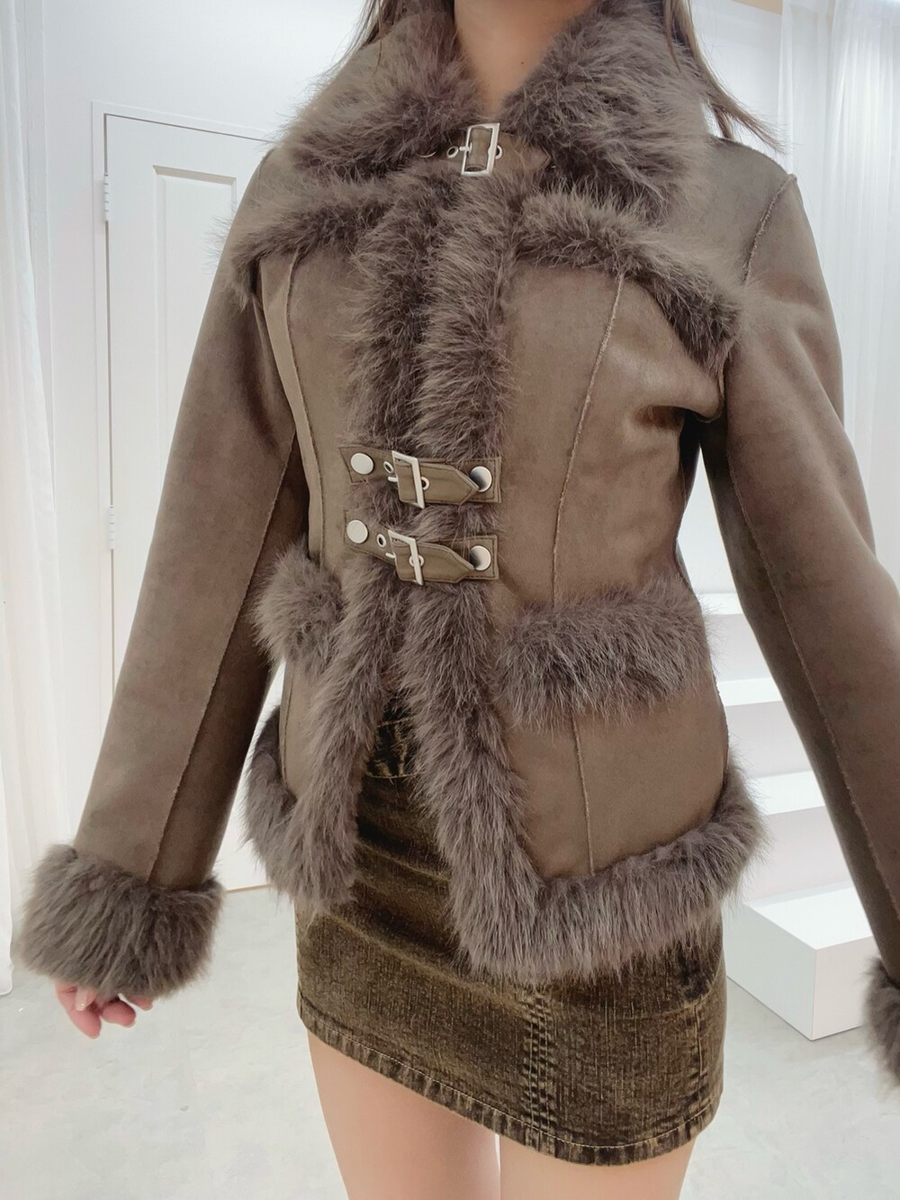 ホワイト系のブーツ、ブラウン系のブルゾン、ブラウン系のデニムスカートを着用したレディースの夏コーディネートの5枚目の写真