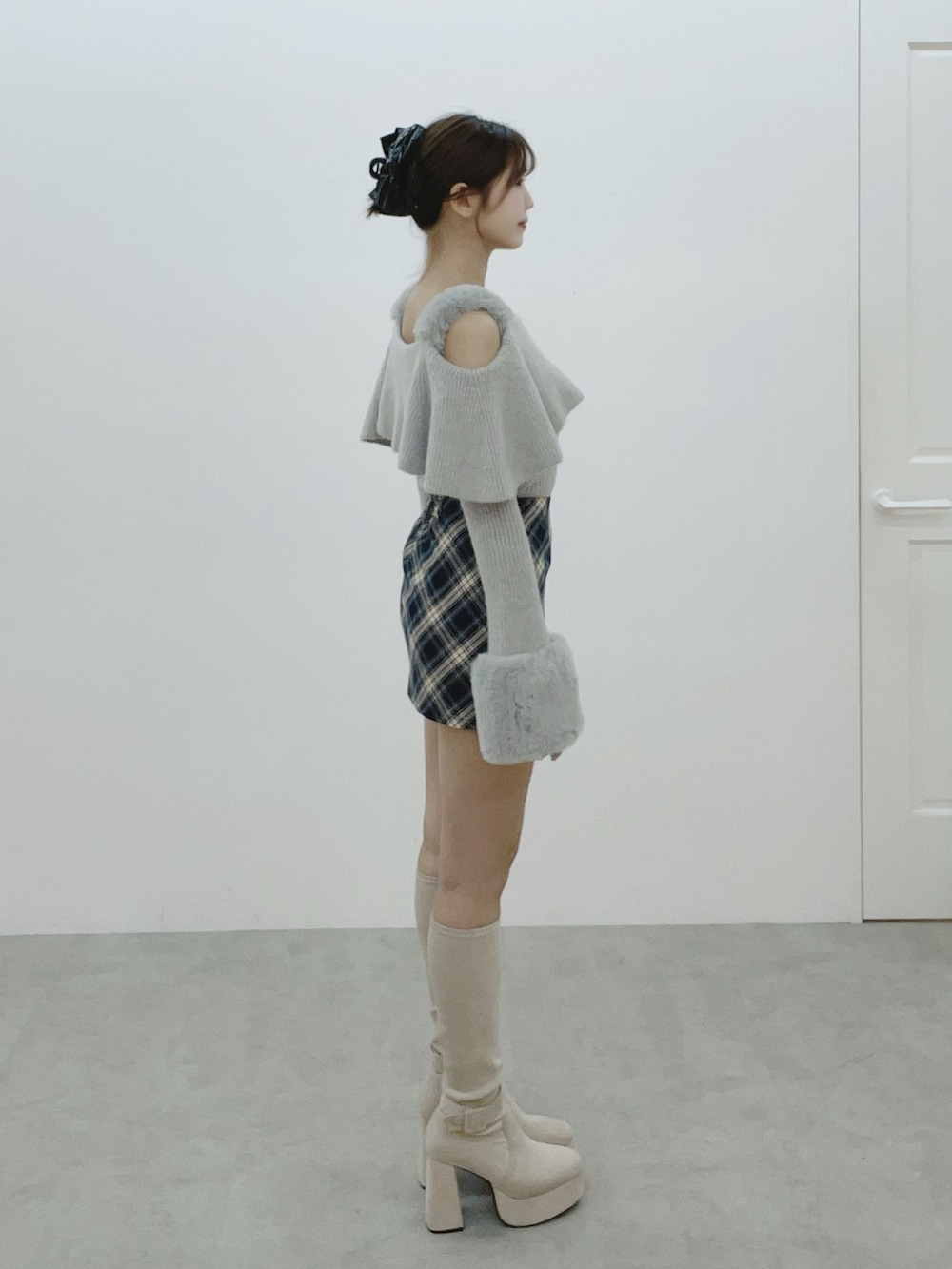 グレー系のニット/セーター、ホワイト系のブーツ、ブルー系のスカートを着用したレディースの秋コーディネートの3枚目の写真