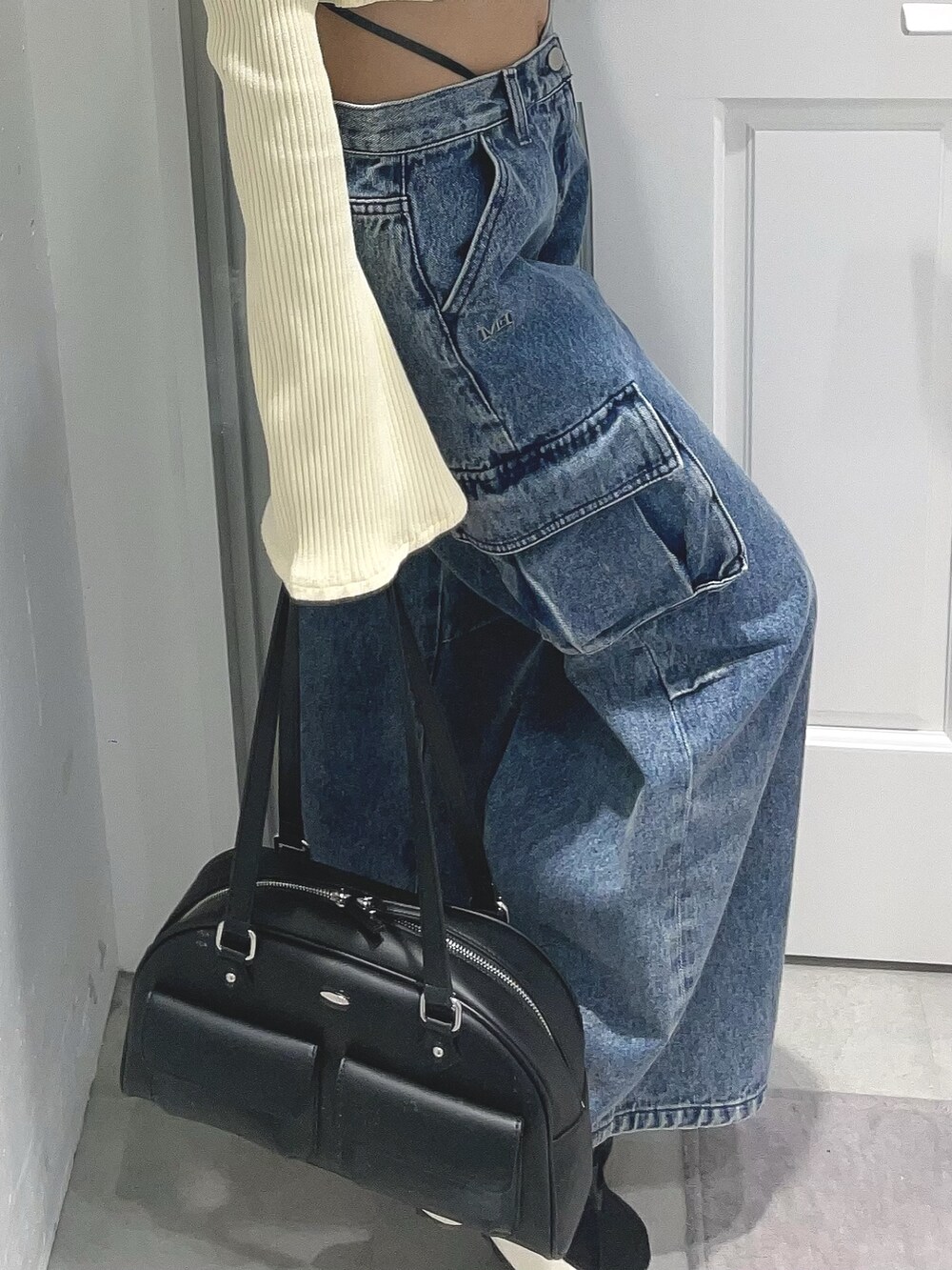 イエロー系のTシャツ/カットソー、ブルー系のデニムパンツ、ブラック系のボストンバッグを着用したレディースの冬コーディネートの7枚目の写真