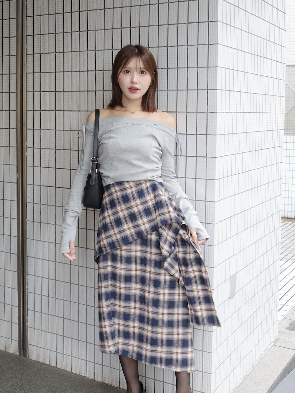 グレー系のTシャツ/カットソー、ブルー系のスカート、ブラック系のショルダーバッグを着用したレディースの秋コーディネートの2枚目の写真