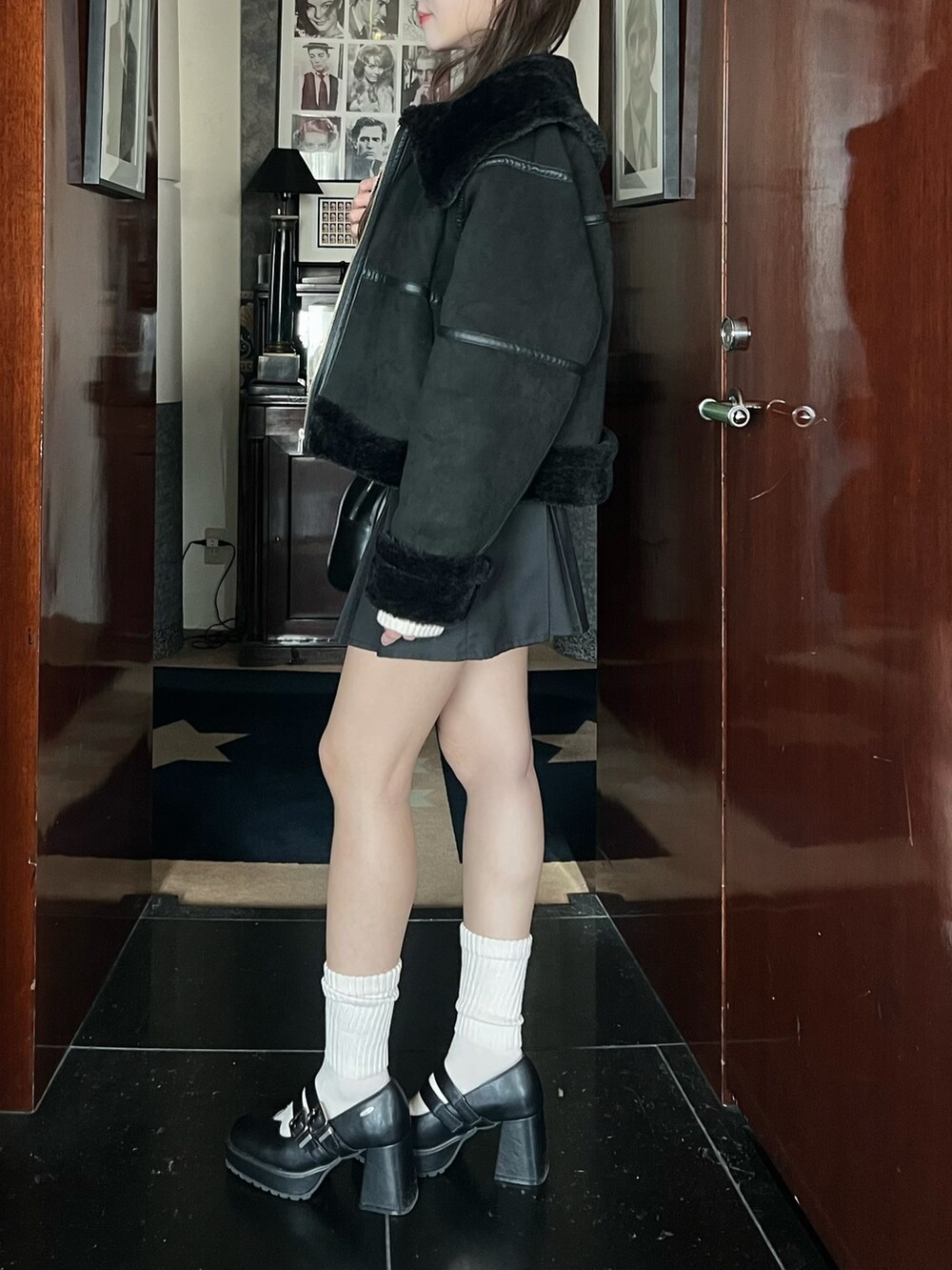 ブラック系のブルゾン、グレー系のスカート、ホワイト系のニット/セーターを着用したレディースの冬コーディネートの7枚目の写真