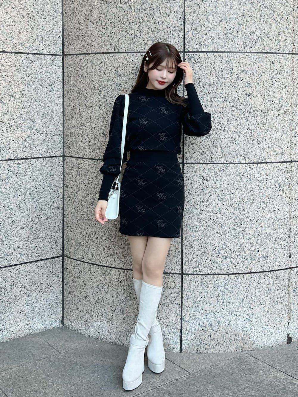 ブラック系のニット/セーター、ホワイト系のブーツ、ブラック系のスカートを着用したレディースの秋コーディネートの3枚目の写真