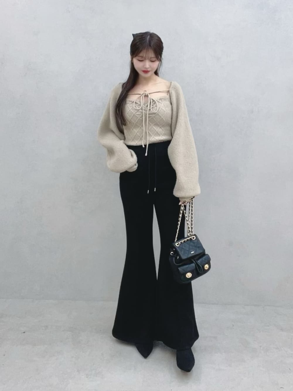ベージュ系のニット/セーター、ブラック系のその他パンツ、ブラック系のブーツを着用したレディースの冬コーディネートの2枚目の写真