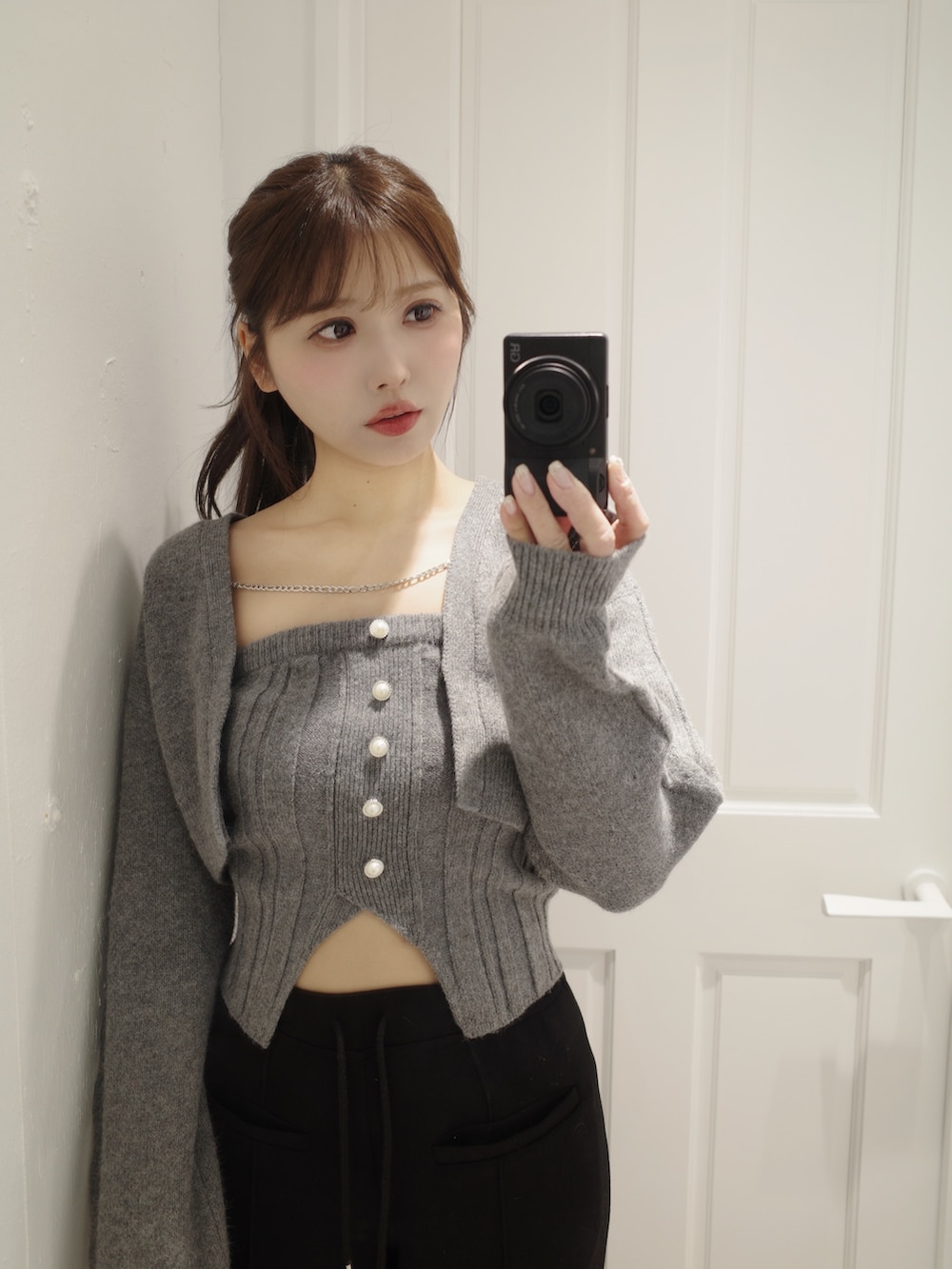 グレー系のニット/セーター、ブラック系のその他パンツ、ホワイト系のバックパック/リュックを着用したレディースの冬コーディネートの9枚目の写真