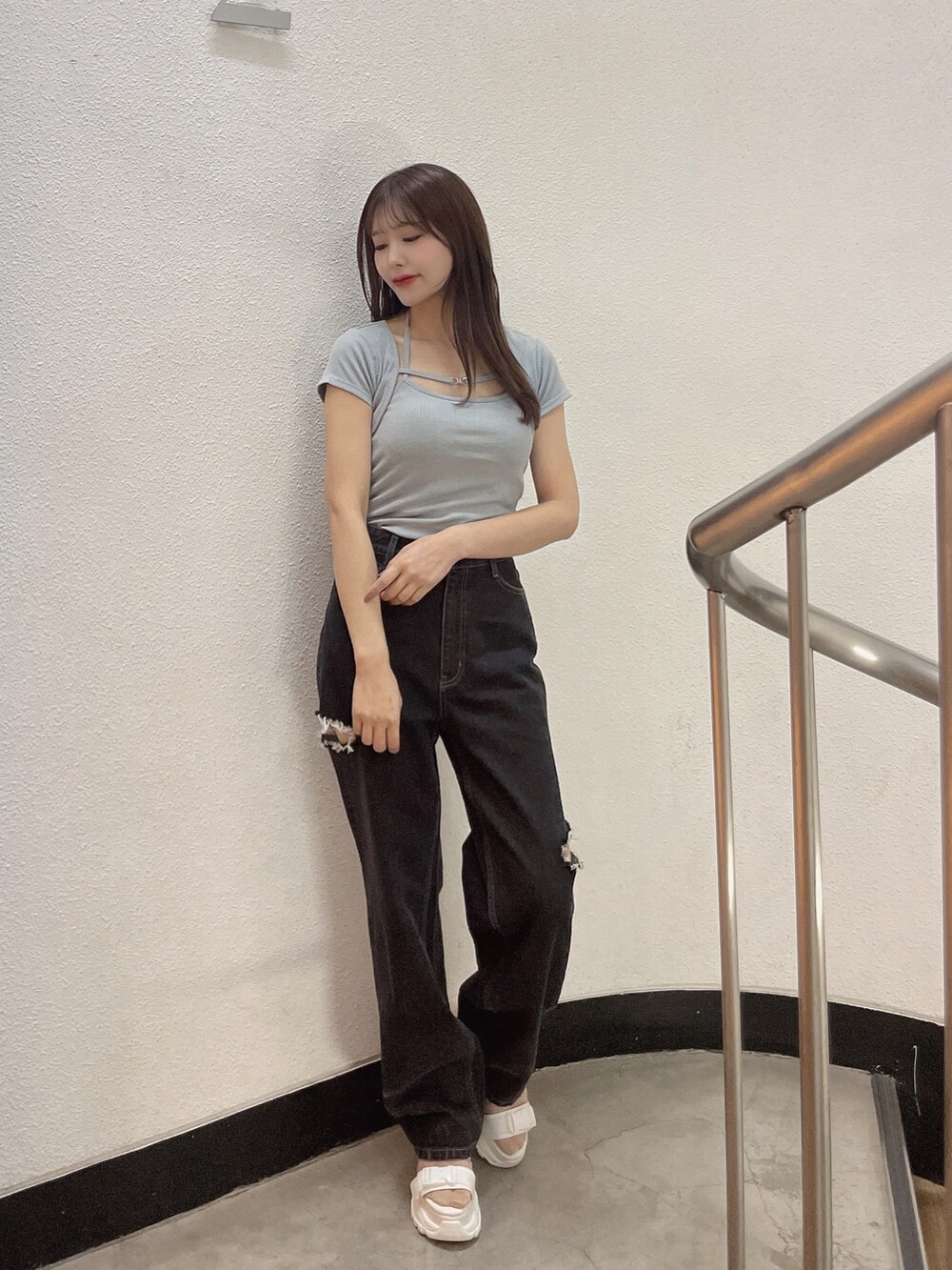 ブルー系のニット/セーター、ブラック系のデニムパンツ、ホワイト系のサンダルを着用したレディースの春コーディネートの6枚目の写真