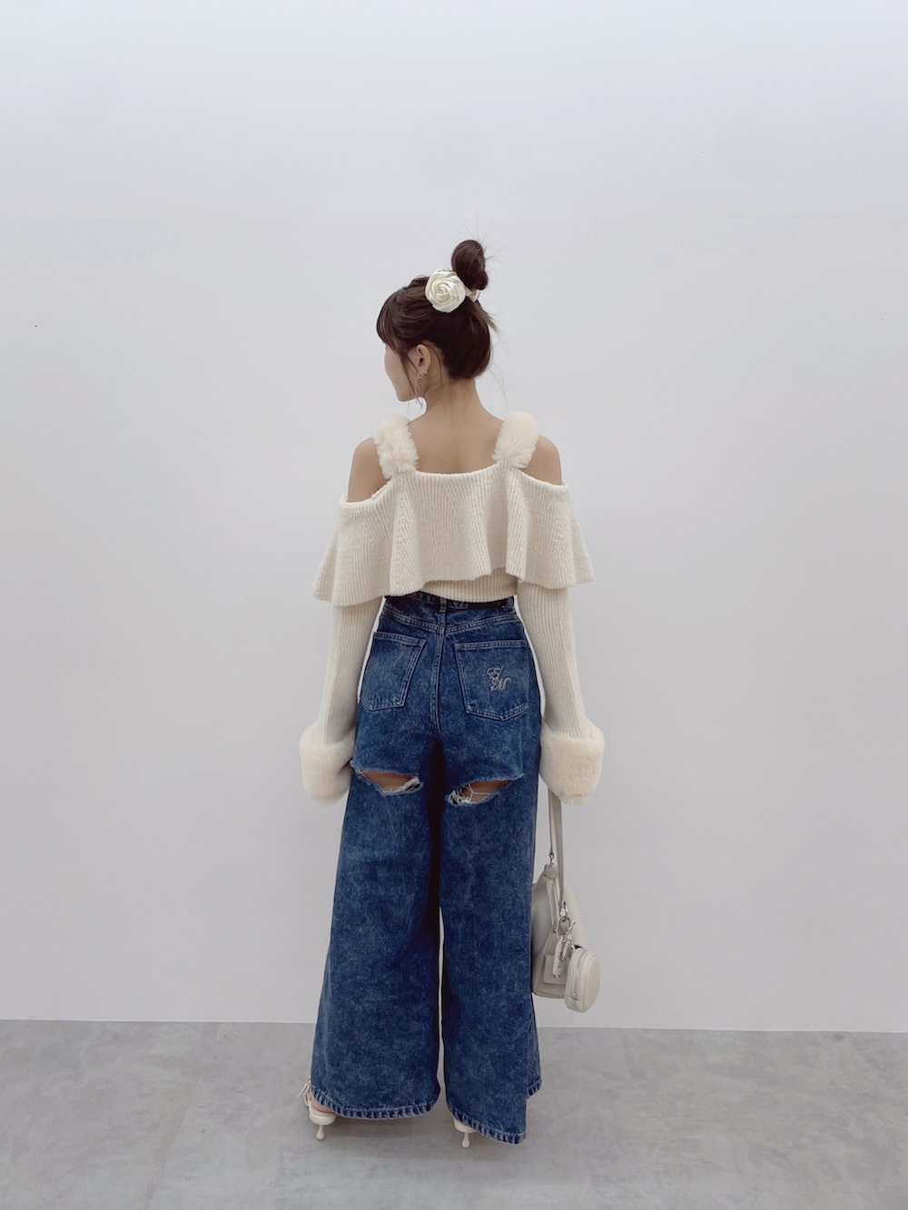 ホワイト系のニット/セーター、ブルー系のデニムパンツ、ホワイト系のパンプスを着用したレディースの秋コーディネートの8枚目の写真