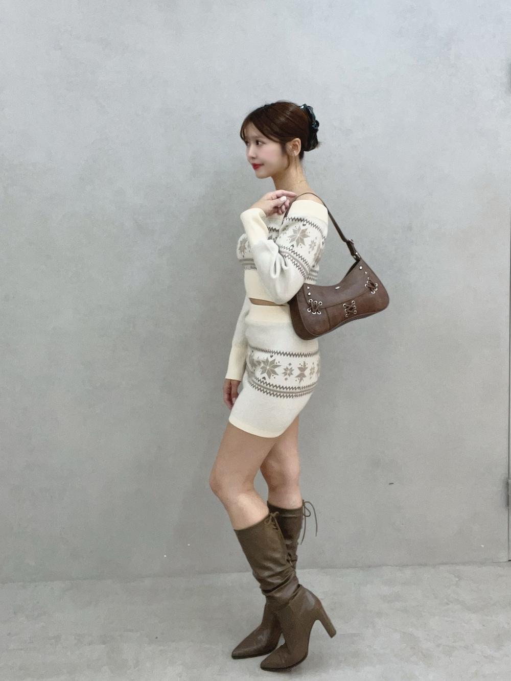 ホワイト系のニット/セーター、ホワイト系のスカート、ブラウン系のブーツを着用したレディースの秋コーディネートの4枚目の写真