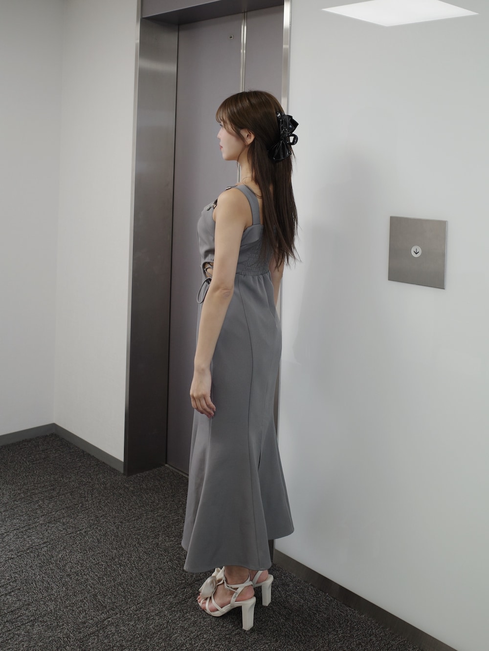 グレー系のワンピース、ホワイト系のサンダルを着用したレディースの夏コーディネートの4枚目の写真