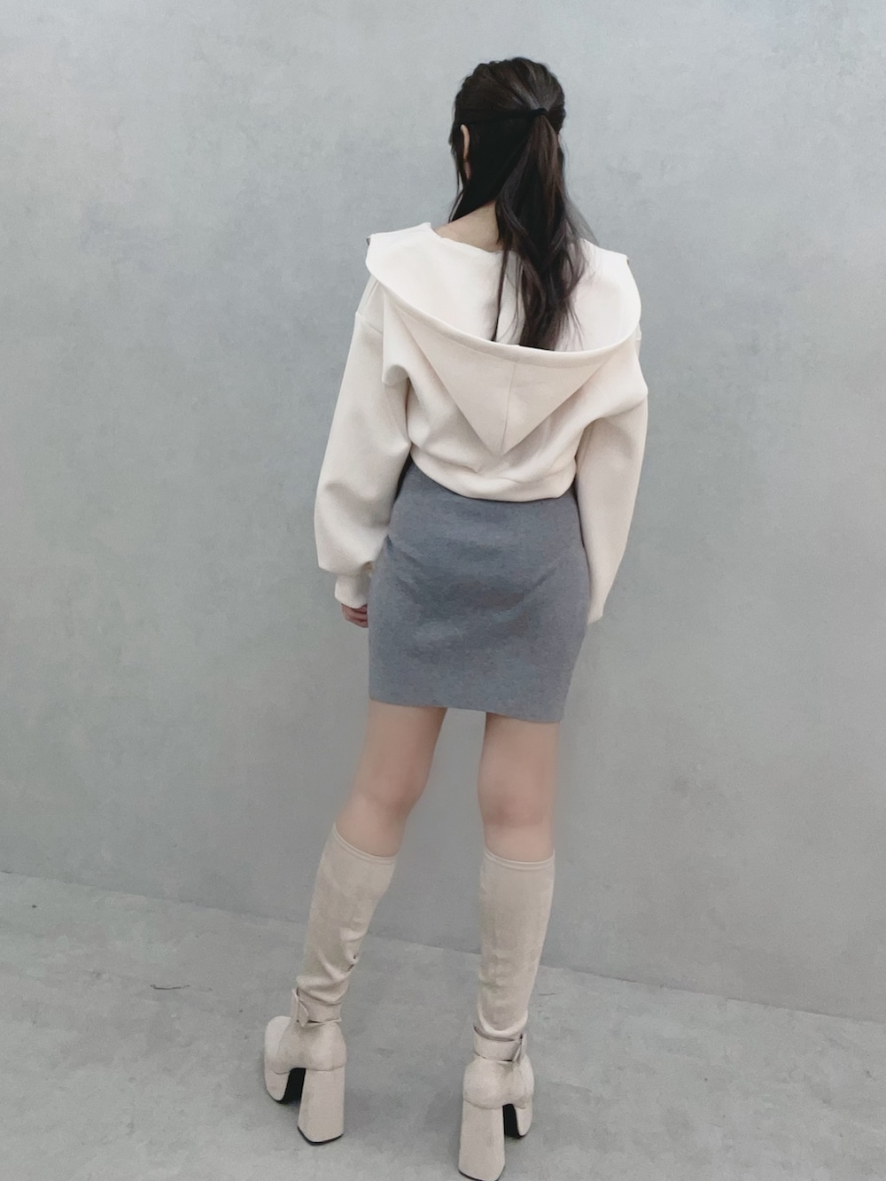 グレー系のワンピース、ホワイト系のパーカー、ホワイト系のブーツを着用したレディースの冬コーディネートの4枚目の写真