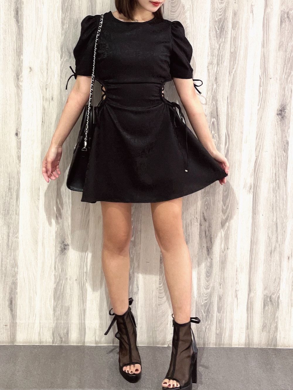 ブラック系のサンダル、ブラック系のハンドバッグ、ブラック系のワンピースを着用したレディースの春コーディネートの2枚目の写真