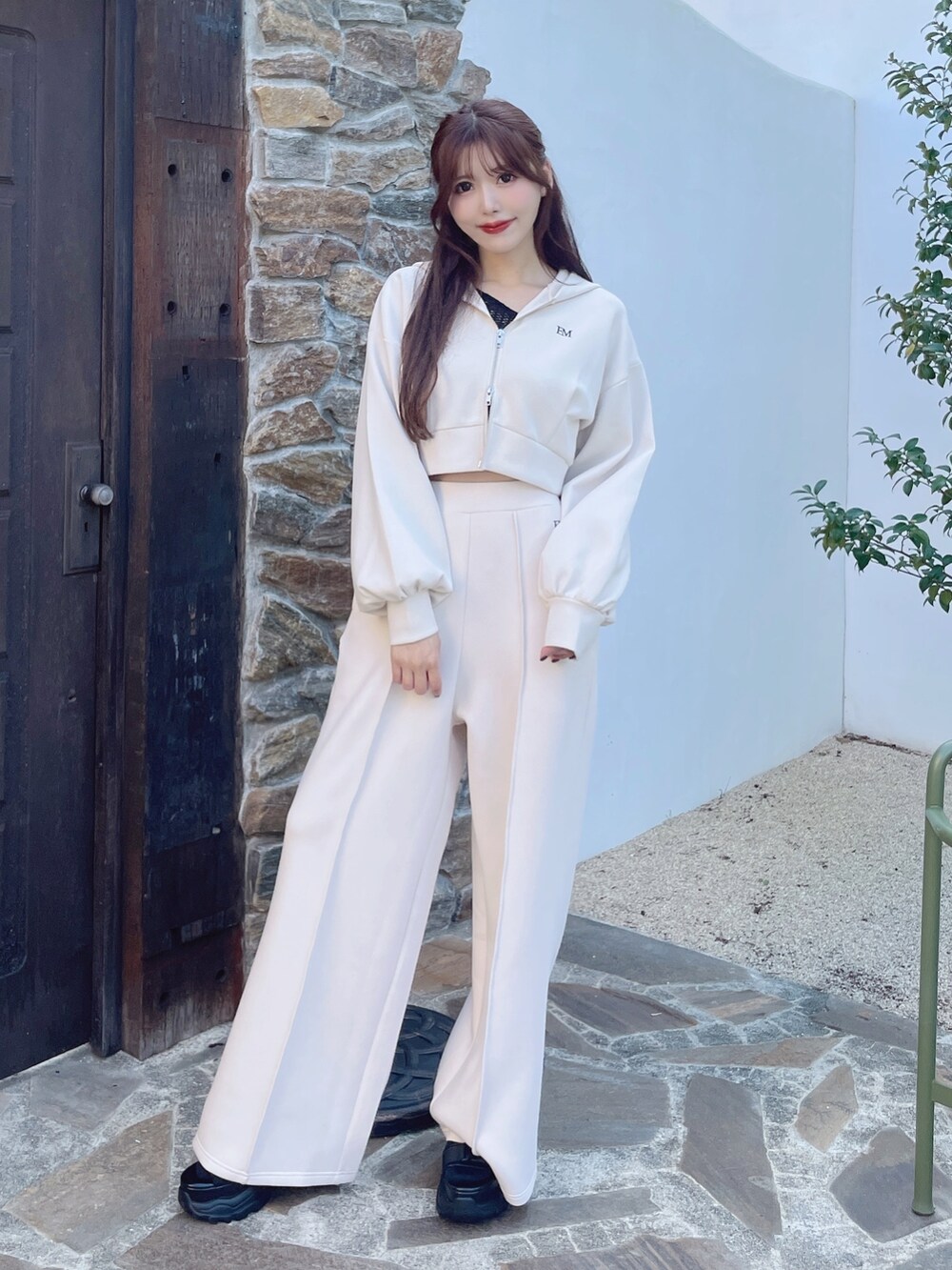 ホワイト系のパーカー、ホワイト系のその他パンツ、ブラック系のサンダルを着用したレディースの冬コーディネートの3枚目の写真