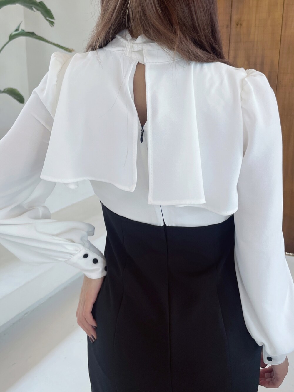 ブラック系のワンピース、ブラック系のショルダーバッグ、ブラック系のパンプスを着用したレディースの冬コーディネートの7枚目の写真