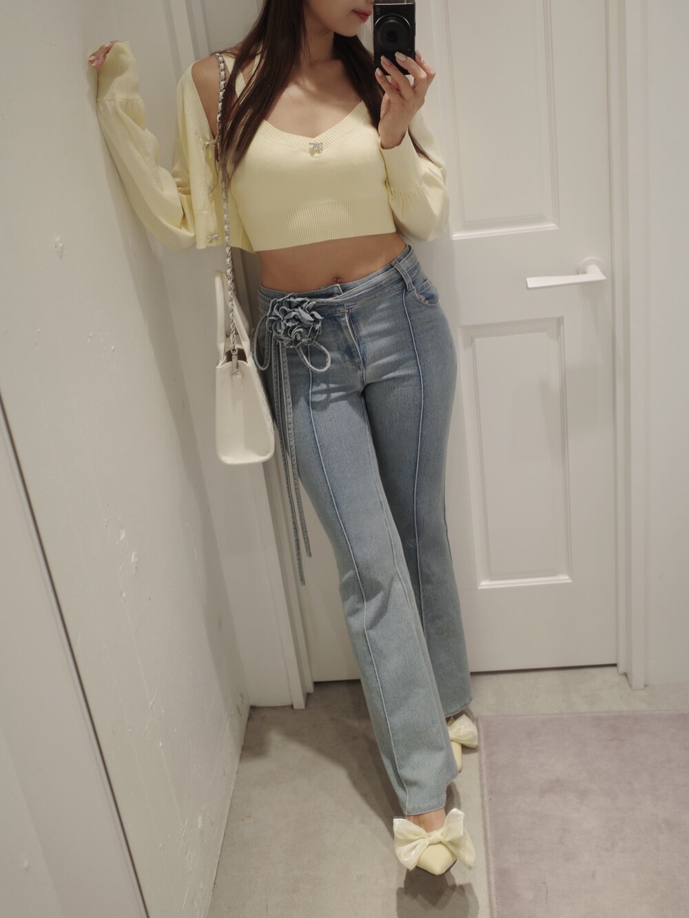 ブルー系のデニムパンツ、イエロー系のパンプス、イエロー系のニット/セーターを着用したレディースの夏コーディネートの5枚目の写真