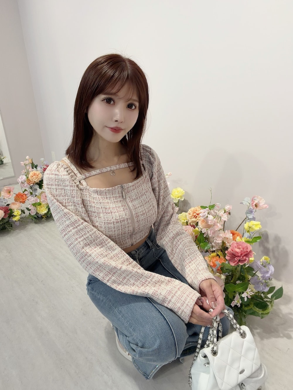 ブルー系のデニムパンツ、ホワイト系のバックパック/リュック、ホワイト系のサンダルを着用したレディースの冬コーディネートの6枚目の写真