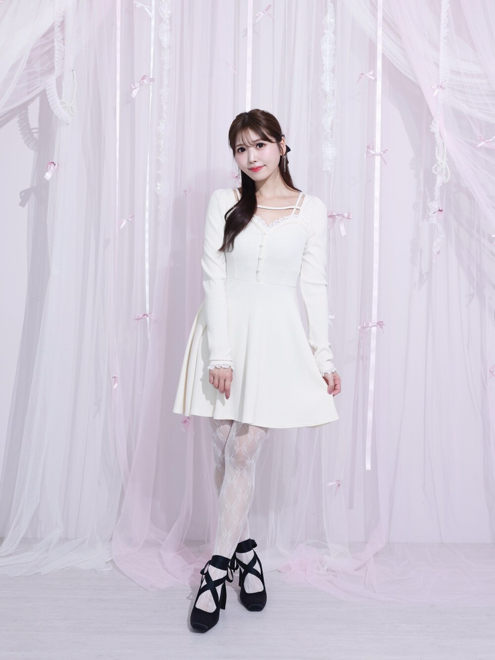 ホワイト系のワンピース、ブラック系のパンプスを着用したレディースの冬コーディネートの3枚目の写真